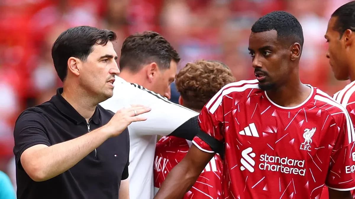 Entrenador hablando con jugador del Liverpool durante partido
