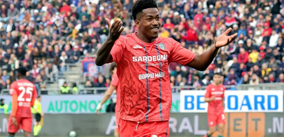 Jugador celebrando en partido con aficionados al fondo