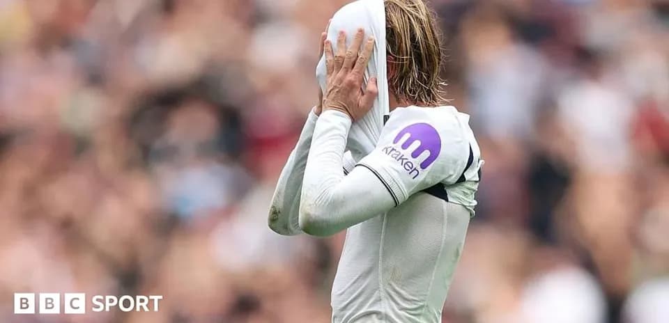 Jugador cubriendo su cara con la camiseta durante partido