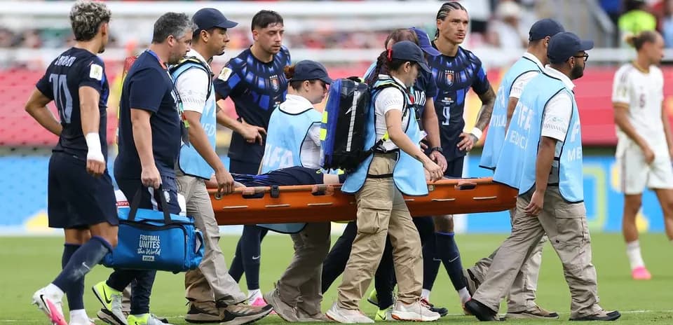 Jugadores y personal médico llevando una camilla