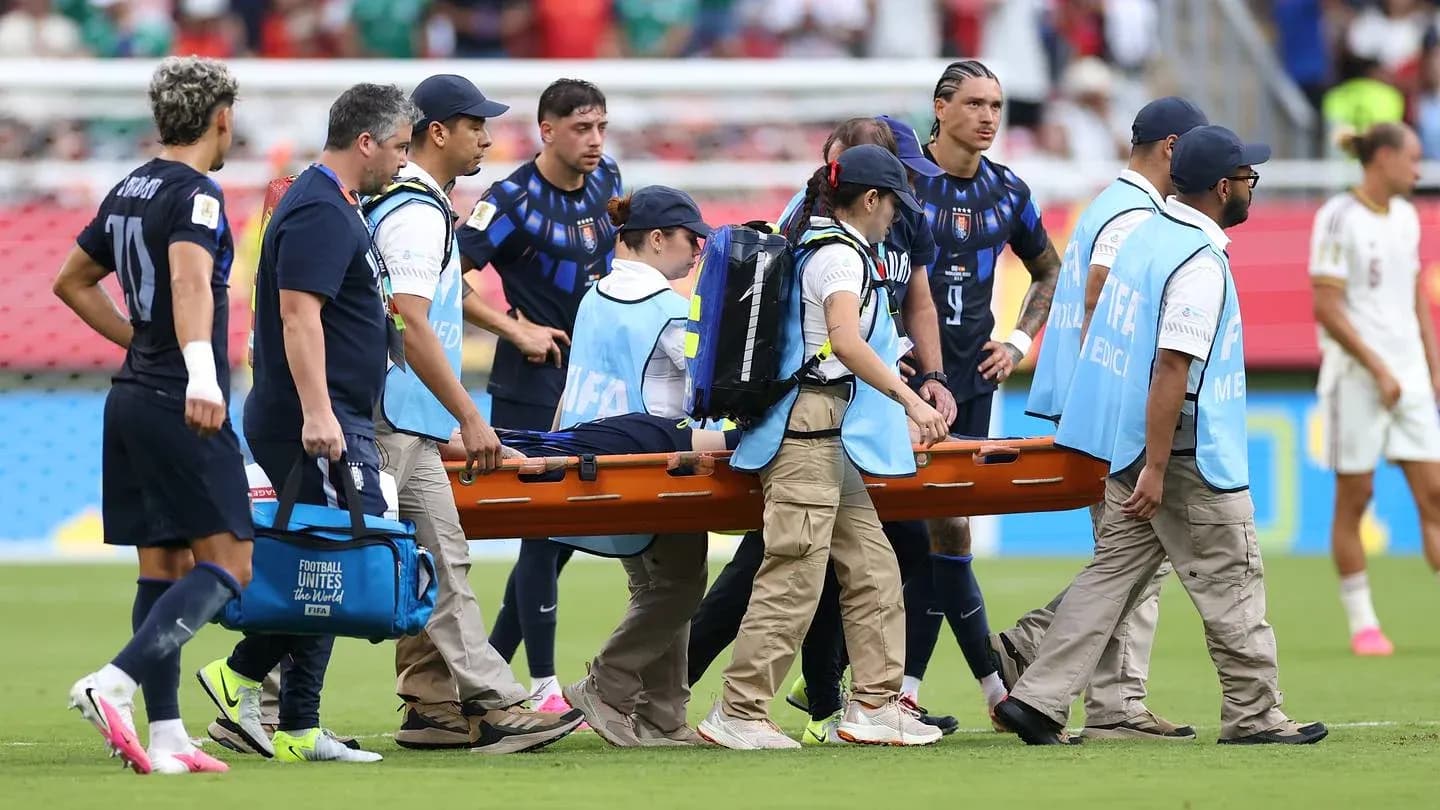 Jugadores y personal médico llevando una camilla