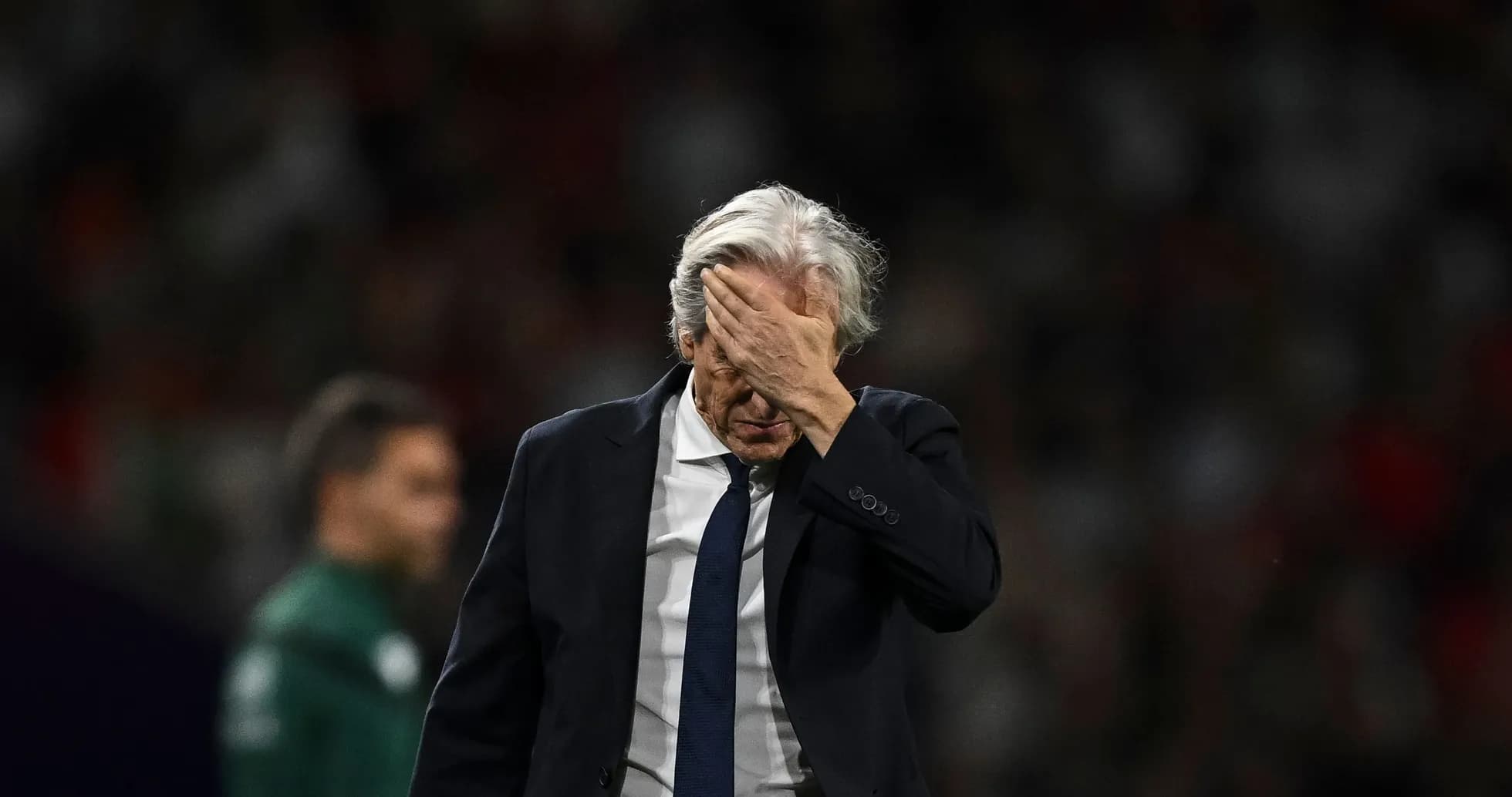 Entrenador con la mano en la frente durante partido
