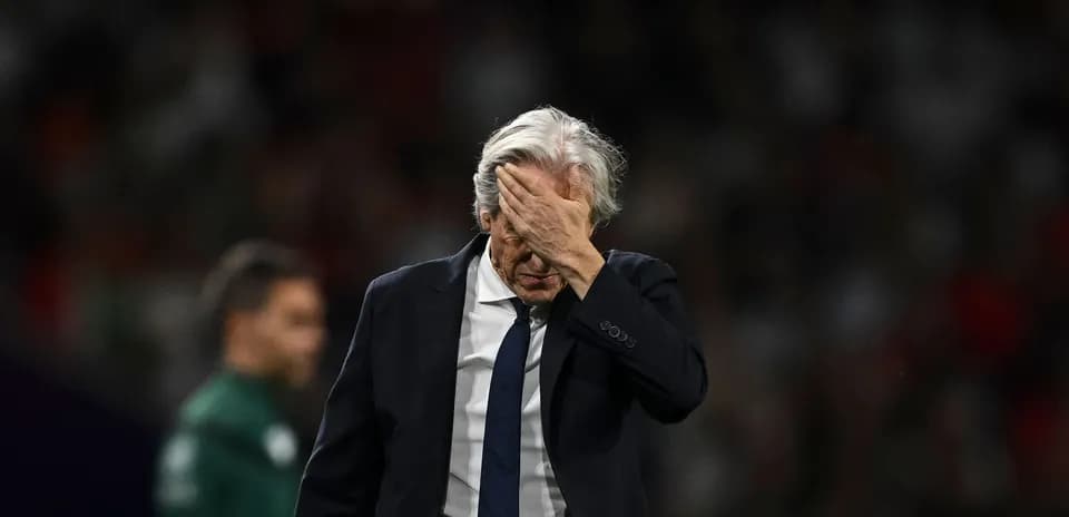 Entrenador con la mano en la frente durante partido
