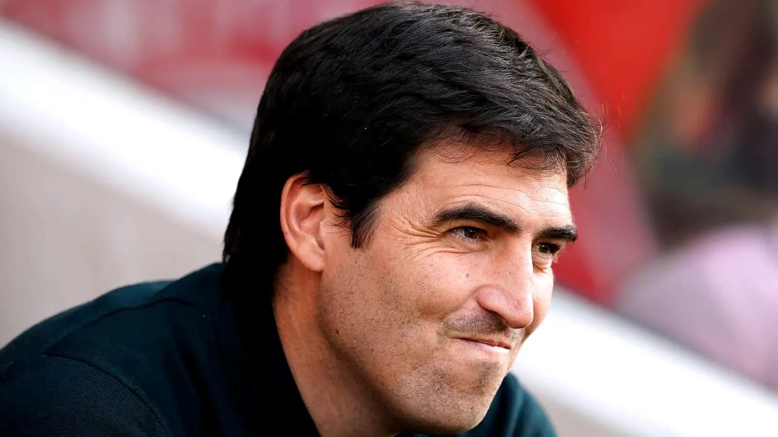 Entrenador observando el partido desde el banquillo