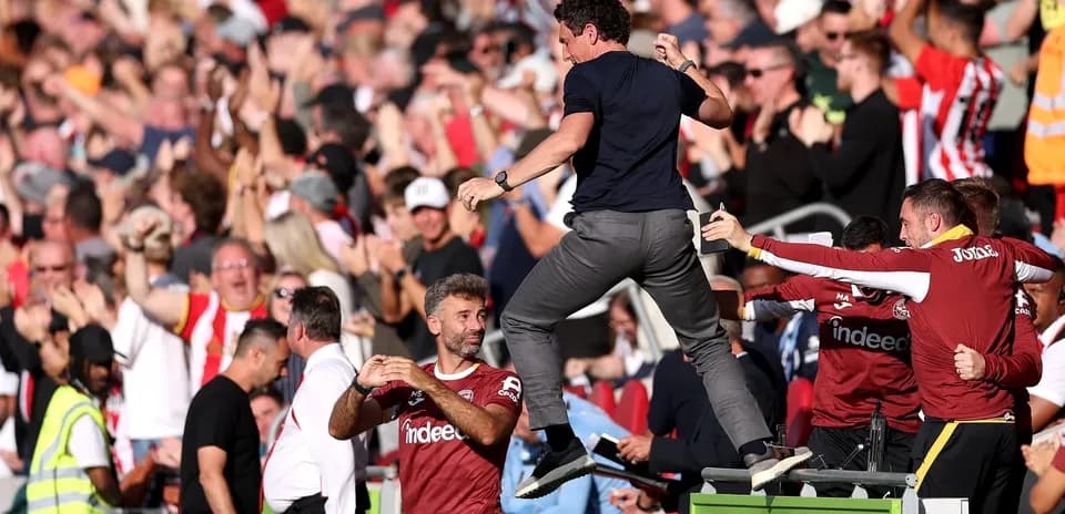 Entrenador celebrando con aficionados durante el partido