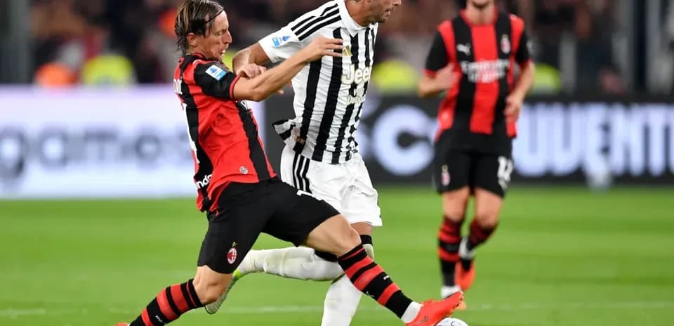 Jugador de AC Milan intentando recuperar el balón a Juventus