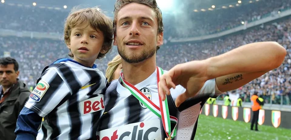 Jugador de Juventus celebrando con un niño en el campo