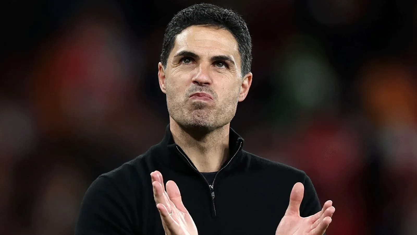 Entrenador aplaudiendo en el campo de fútbol