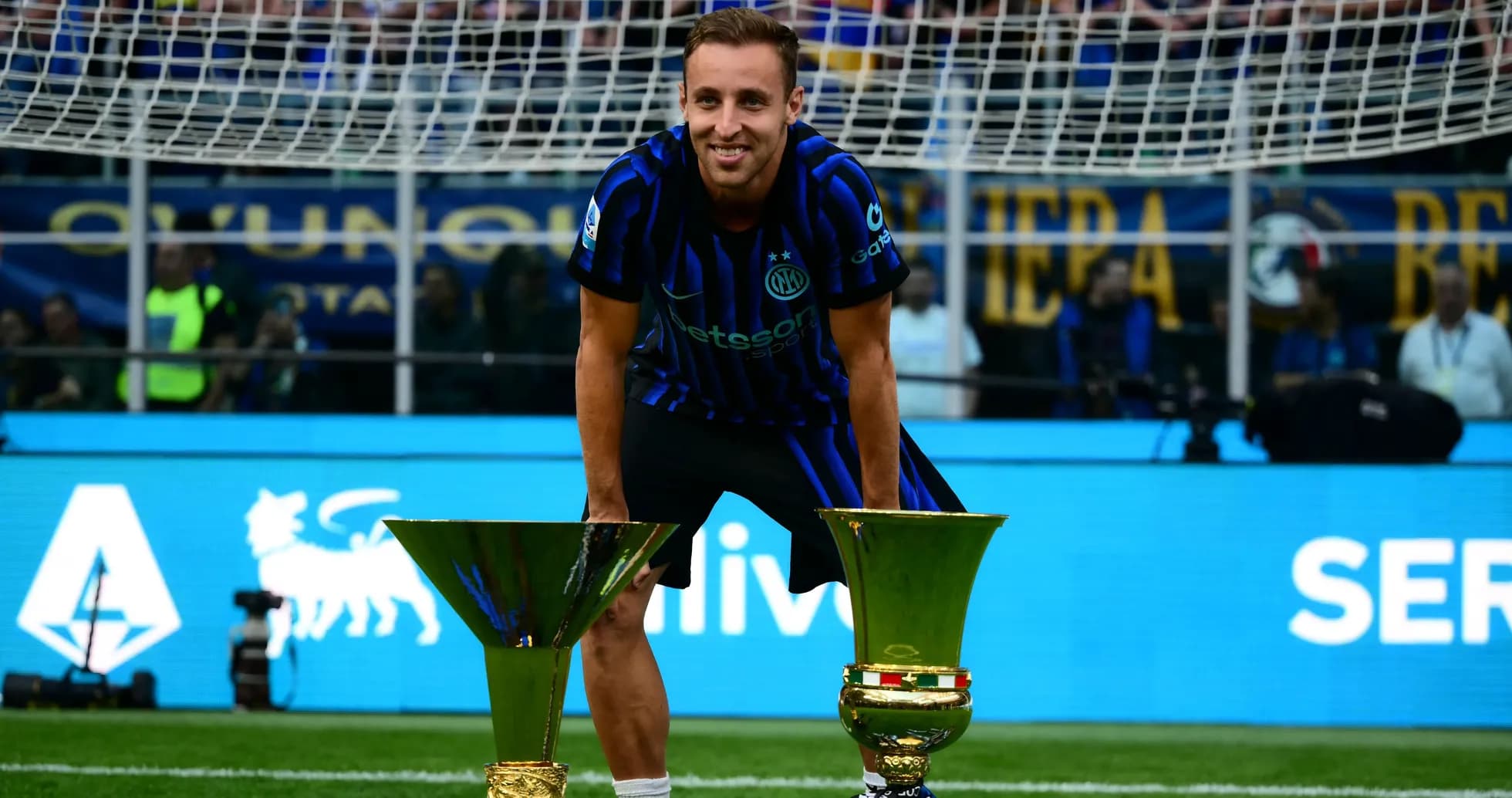 Jugador de Inter celebrando con trofeos en el campo
