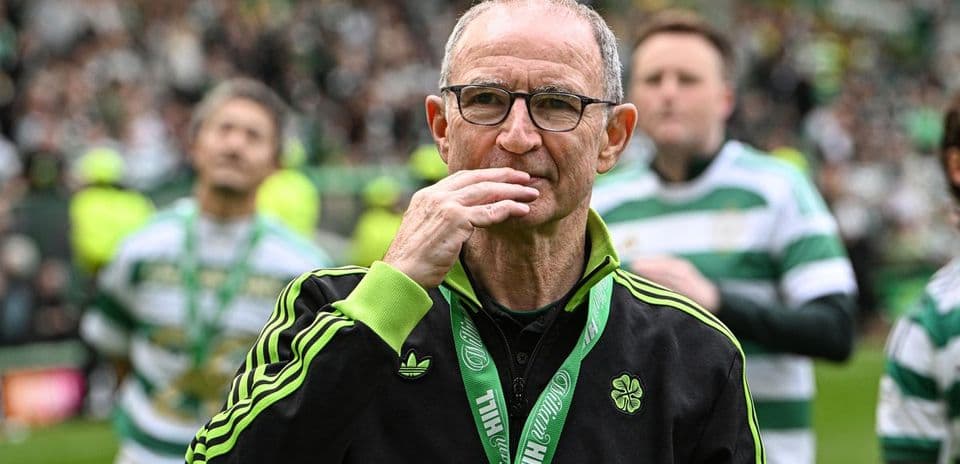 Entrenador en el campo con medalla y aficionados detrás