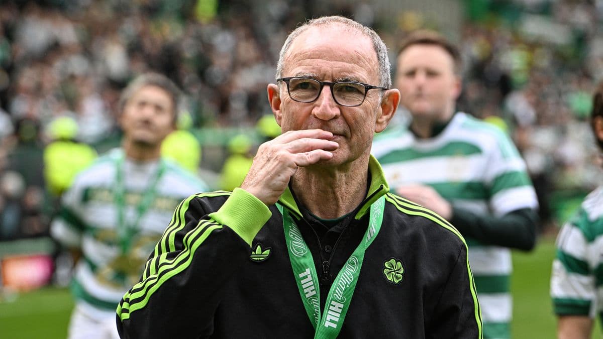 Entrenador en el campo con medalla y aficionados detrás