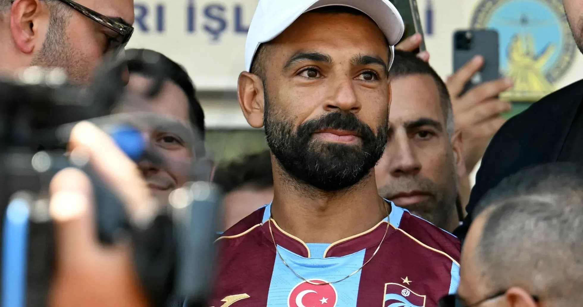 Jugador con camiseta de Trabzonspor rodeado de personas