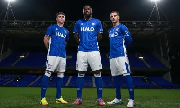 Tres jugadores posando en el campo con uniformes azules