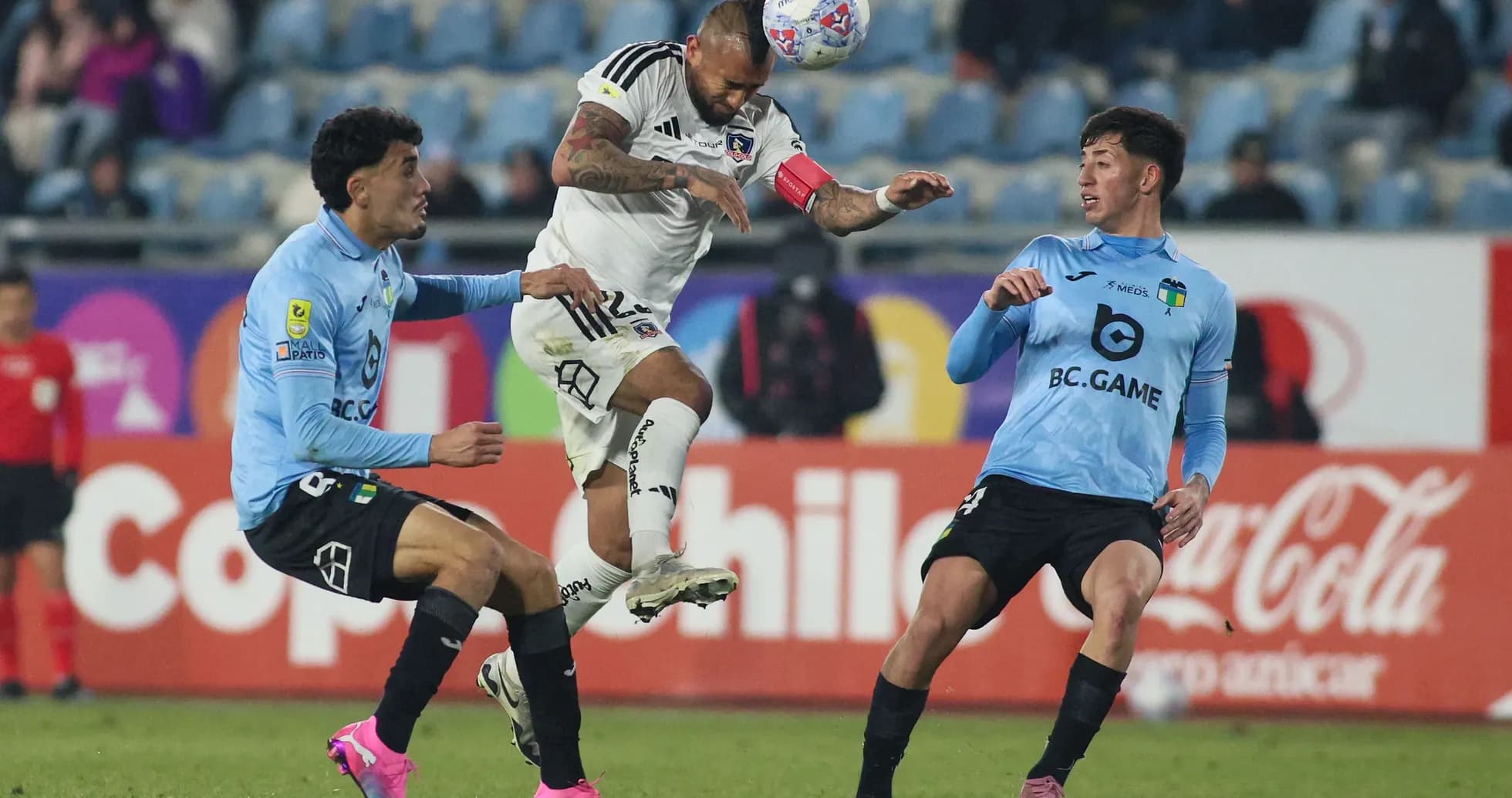 Jugador de Colo Colo saltando entre oponentes