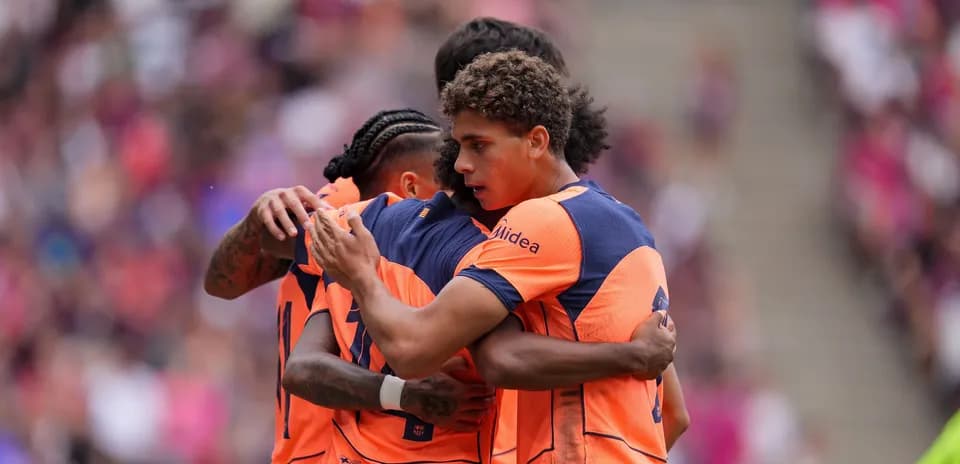 Jugadores abrazándose en celebración durante un partido