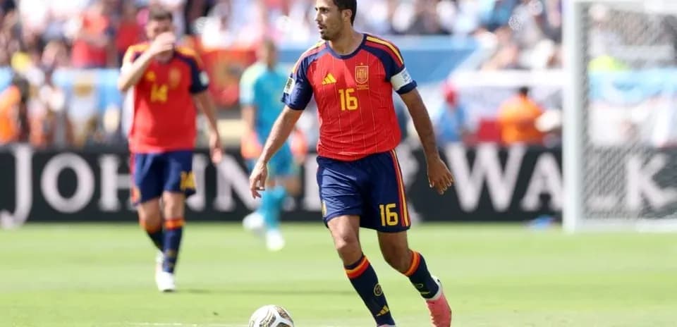 Jugador de España corriendo con el balón en el campo