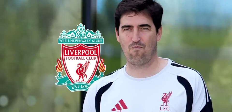 Entrenador de Liverpool frente al escudo del club