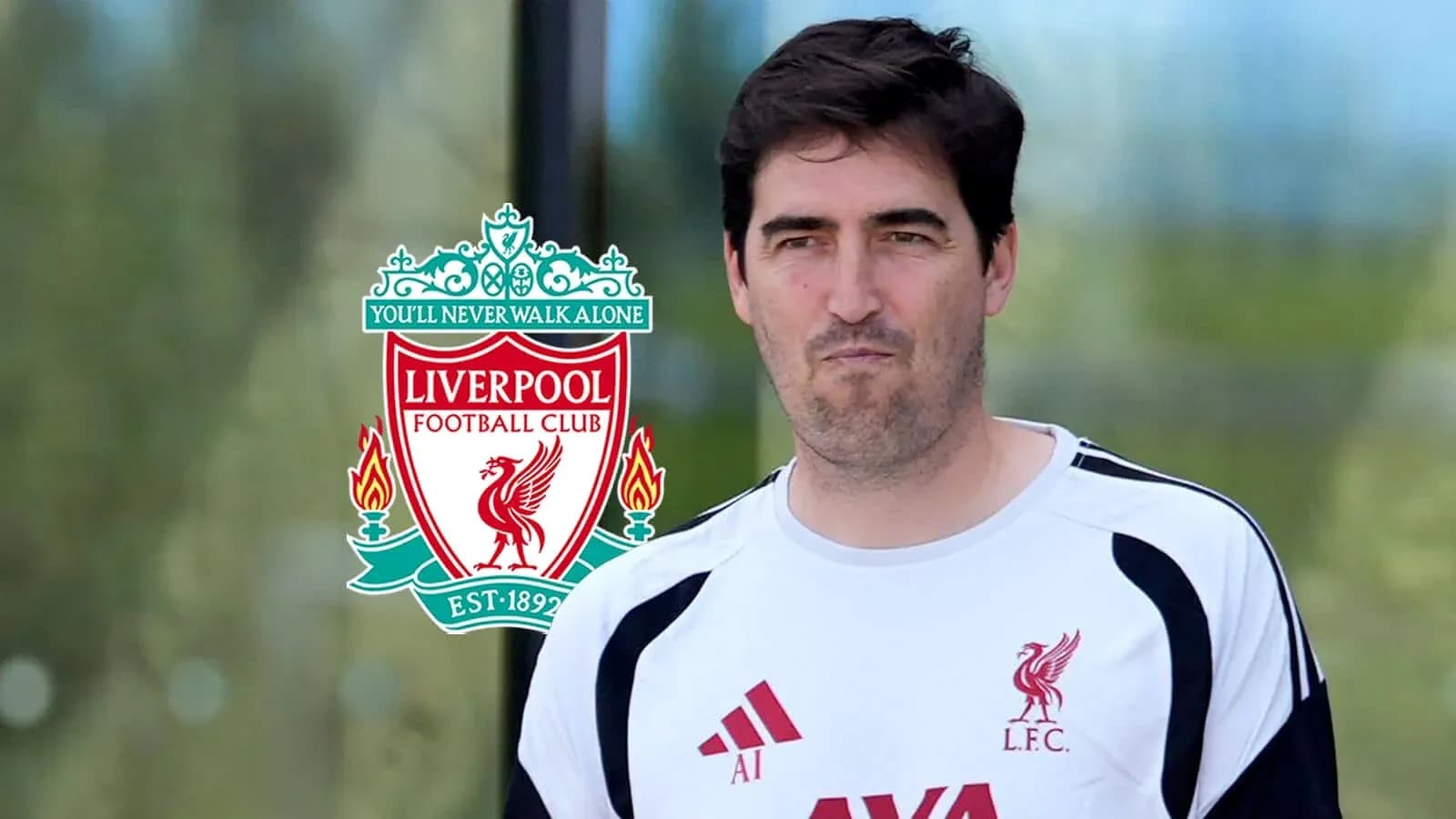 Entrenador de Liverpool frente al escudo del club