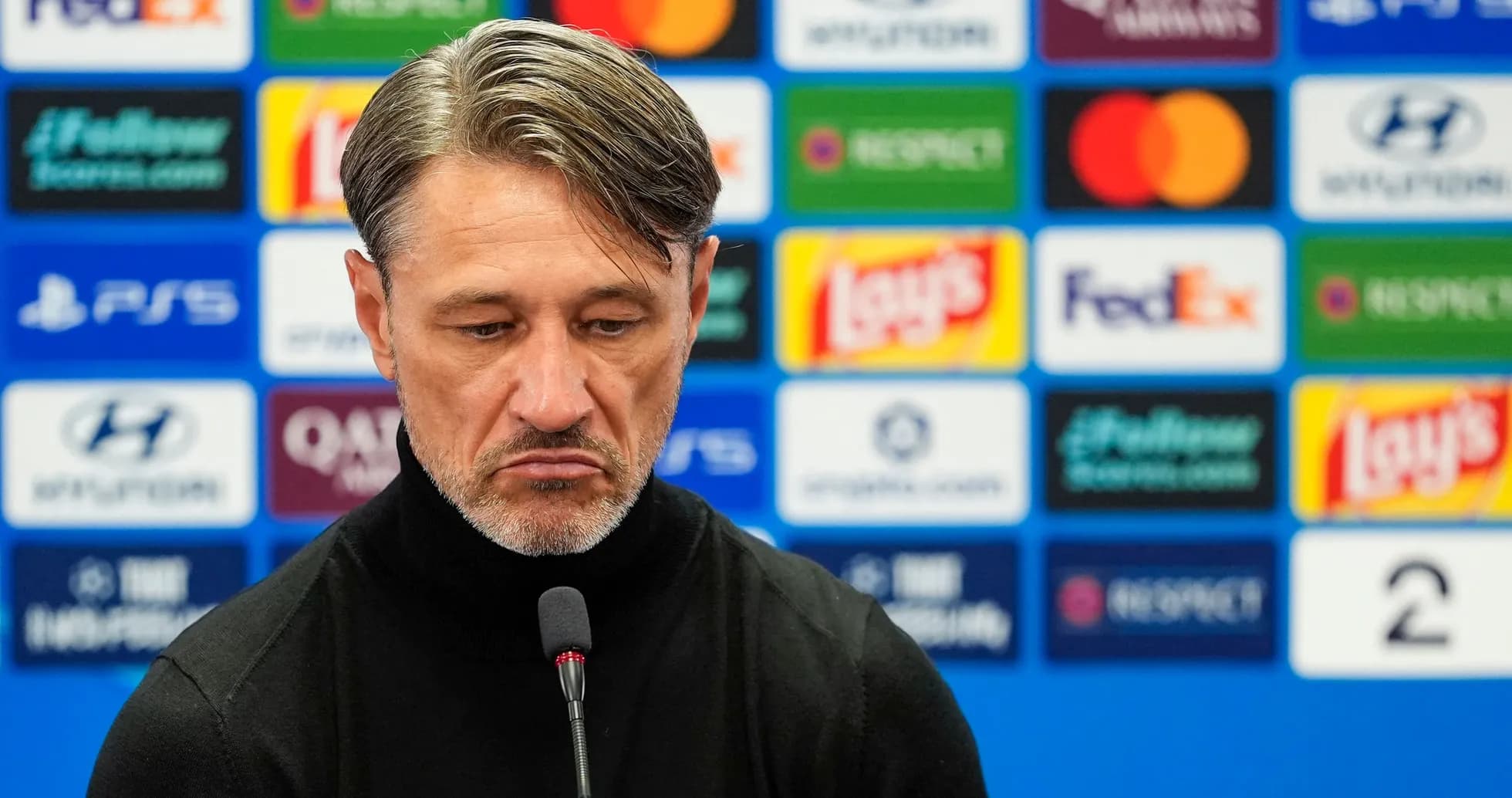 Entrenador en conferencia de prensa con fondo de patrocinadores
