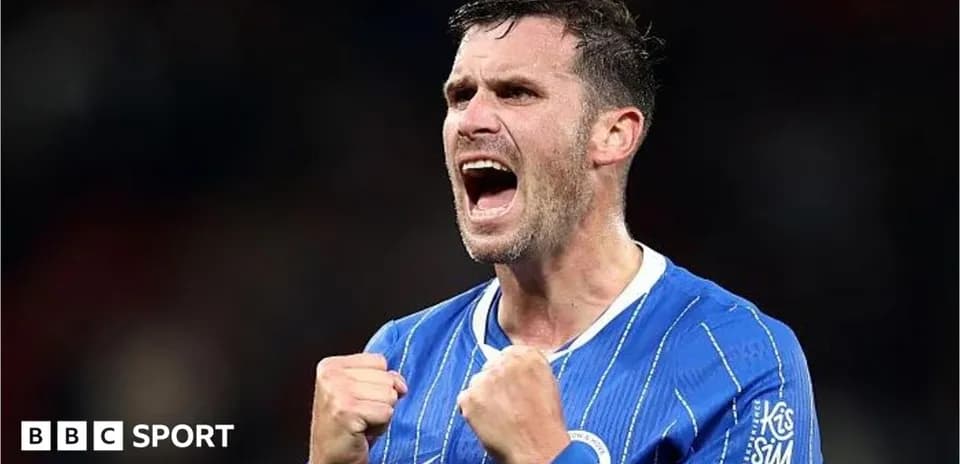 Jugador celebrando con puños cerrados en camiseta azul