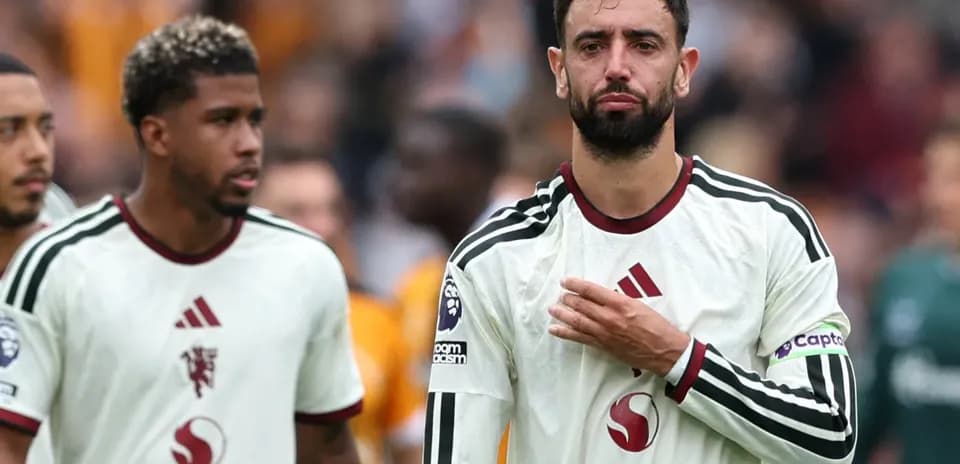 Jugadores caminando tras el partido con camisetas blancas
