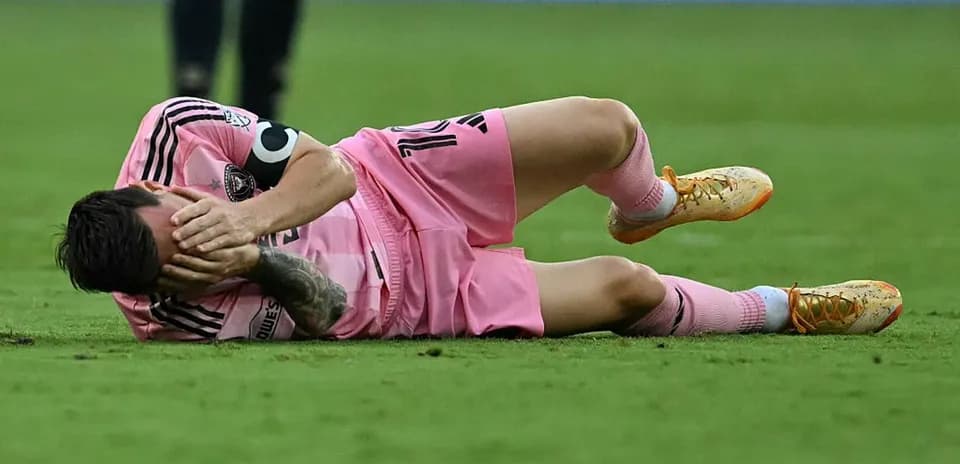Jugador en el suelo con uniforme rosa, lesionado