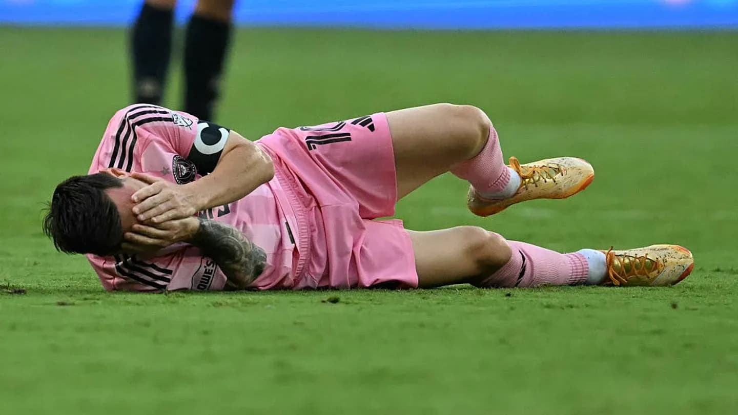Jugador en el suelo con uniforme rosa, lesionado