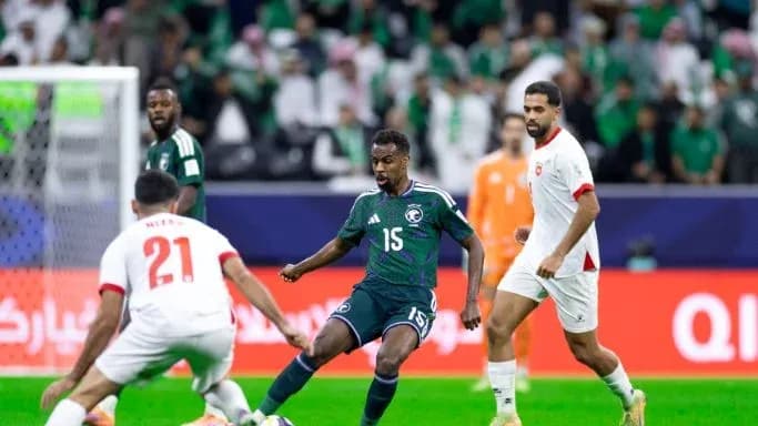 Jugador saudí driblando entre oponentes en partido