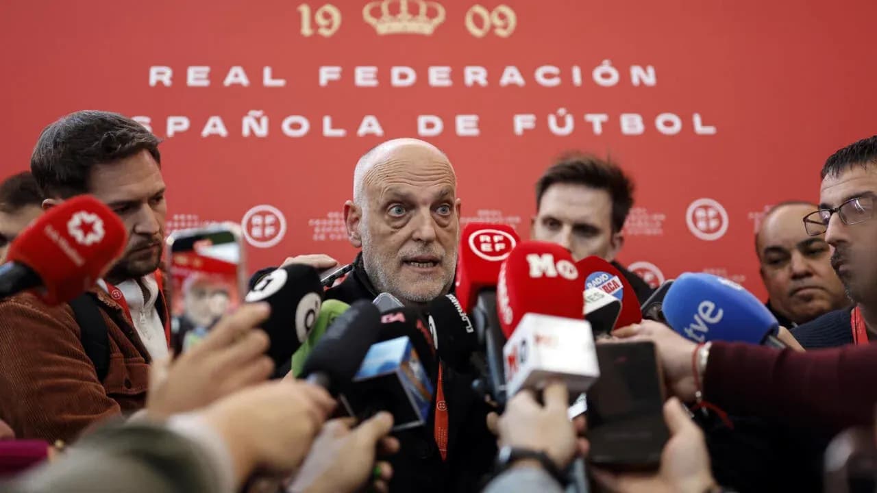Persona hablando en conferencia de prensa rodeado de periodistas