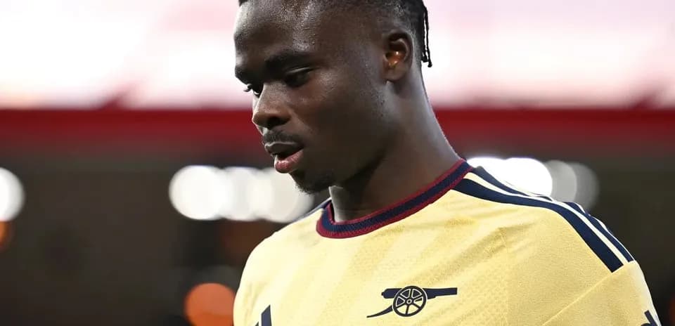 Jugador de Arsenal en camiseta amarilla mirando hacia abajo