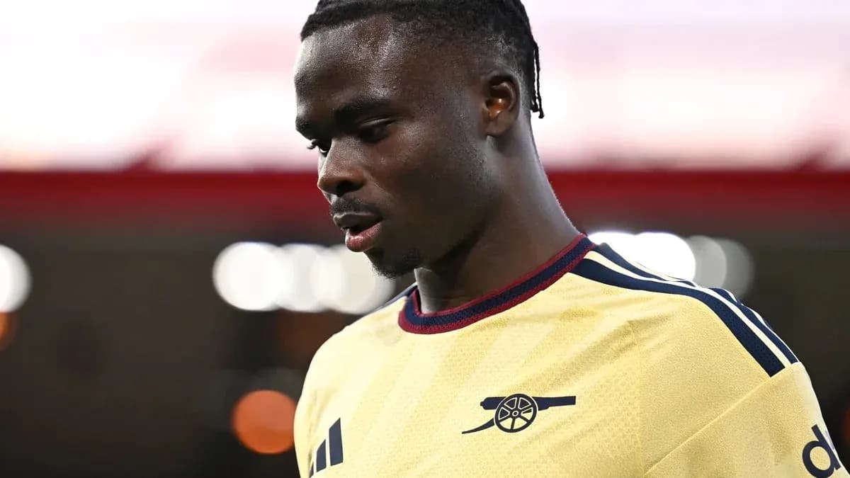 Jugador de Arsenal en camiseta amarilla mirando hacia abajo