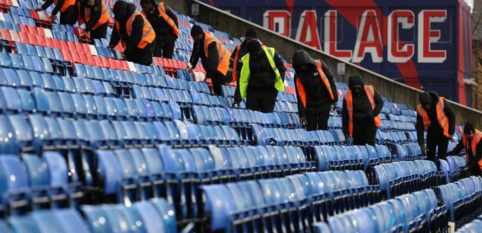 Trabajadores limpiando asientos en el estadio