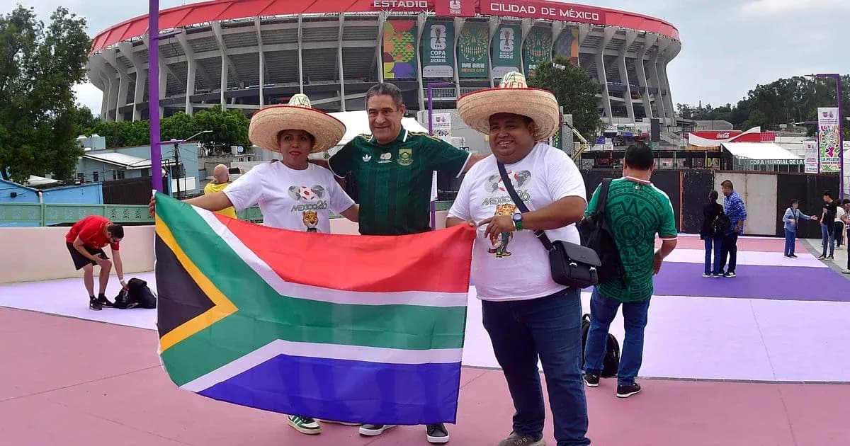 Tres aficionados con sombreros sosteniendo bandera de Sudáfrica