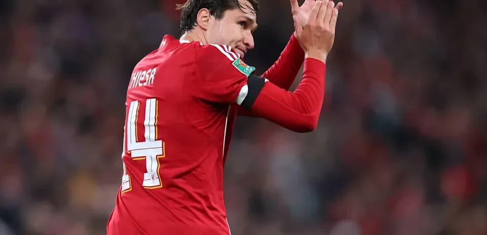 Jugador aplaudiendo con camiseta roja durante partido