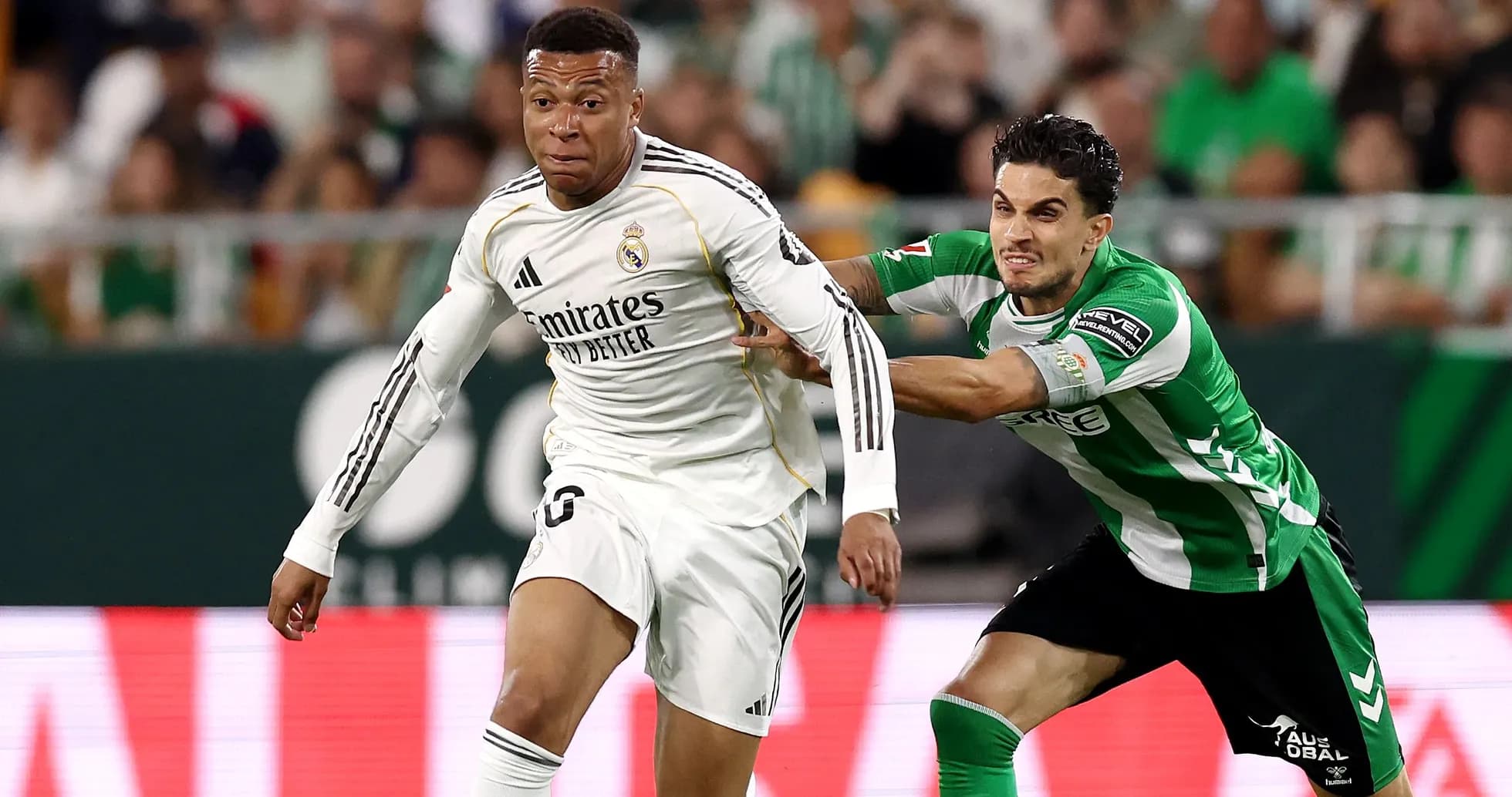 Jugador de Real Madrid corriendo mientras es sujetado