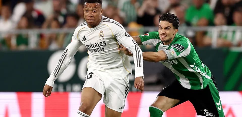 Jugador de Real Madrid corriendo mientras es sujetado