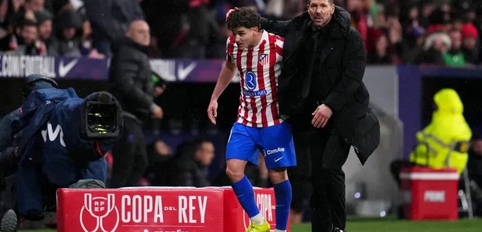 Jugador del Atlético siendo sustituido por el entrenador