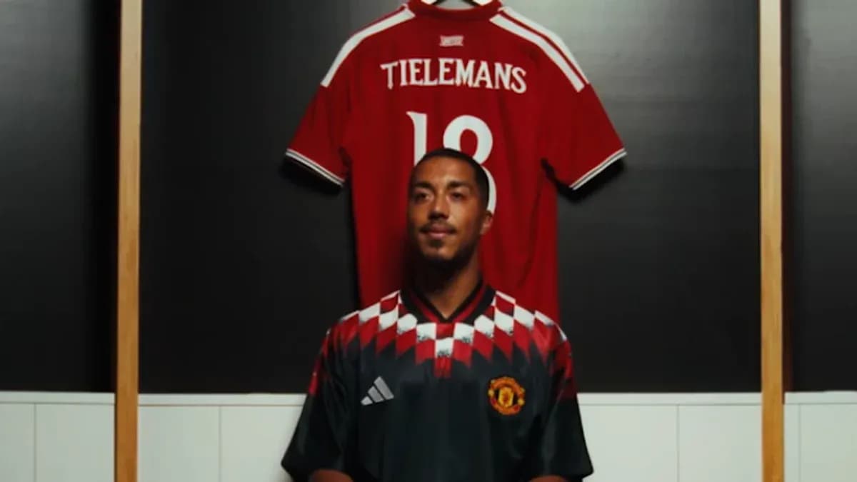Jugador posando frente a camisetas en vestuario
