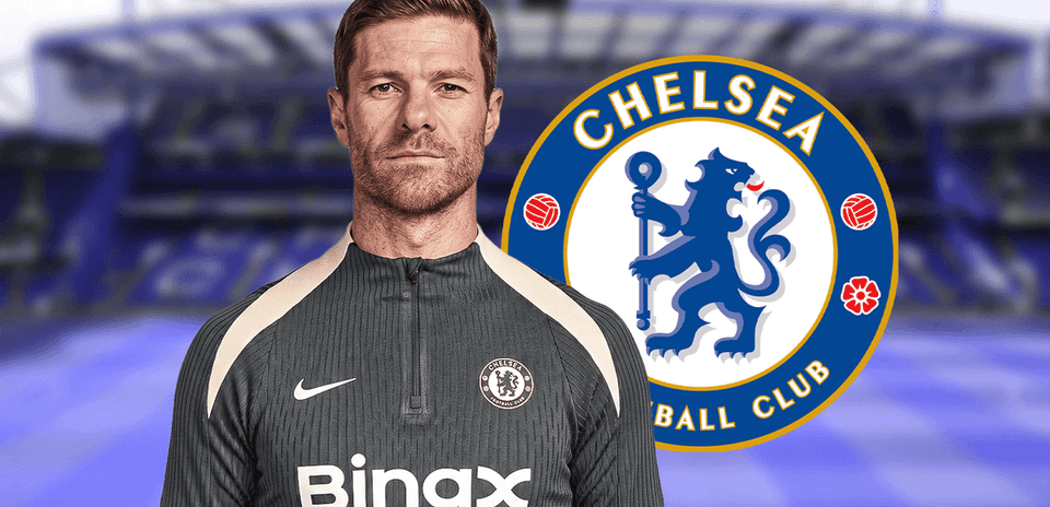 Entrenador posando frente al escudo del Chelsea
