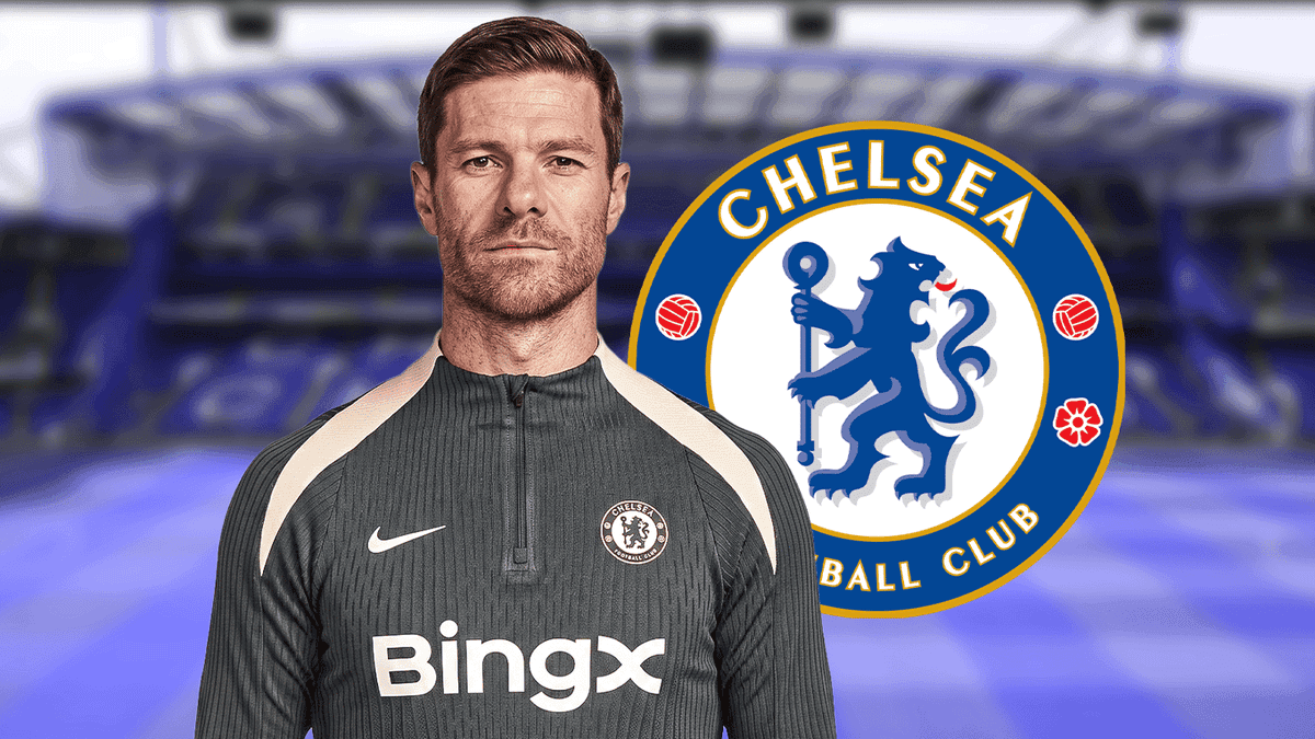 Entrenador posando frente al escudo del Chelsea