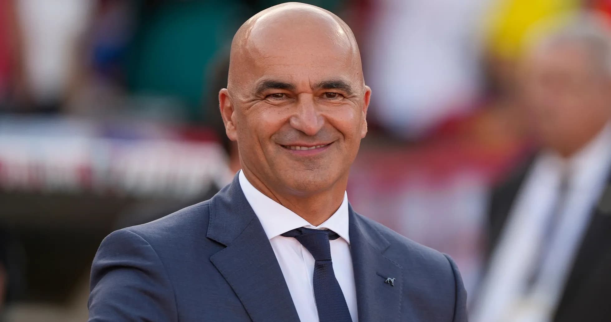 Entrenador sonriendo en evento deportivo al aire libre