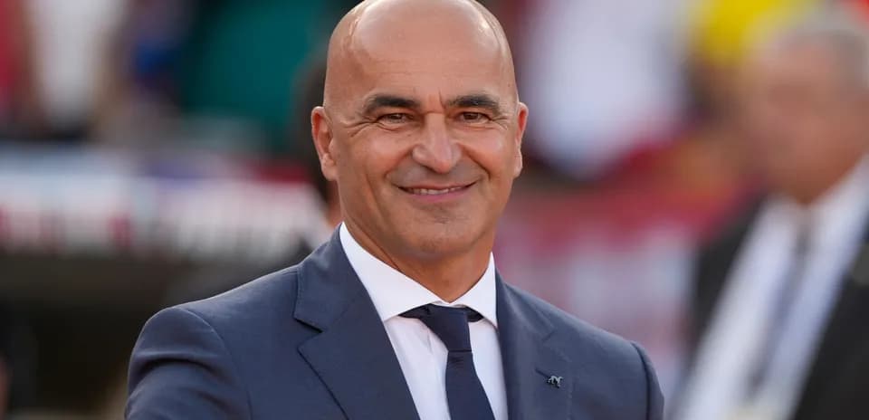 Entrenador sonriendo en evento deportivo al aire libre