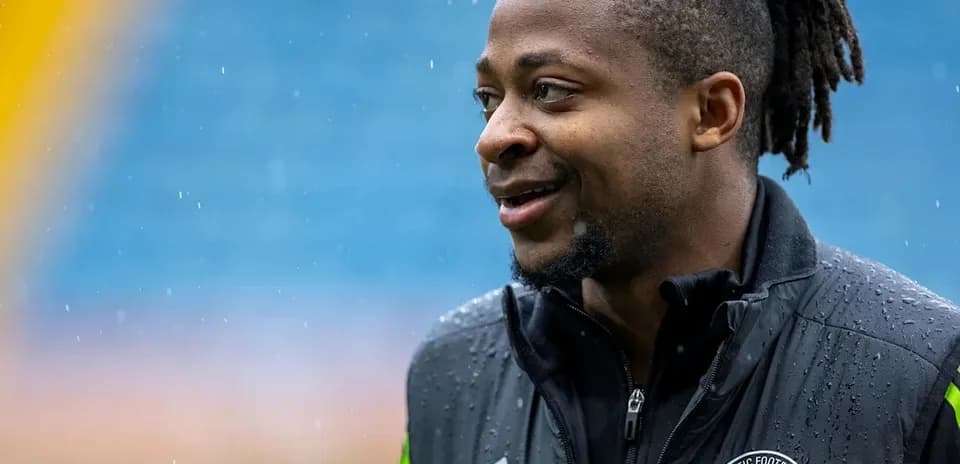 Jugador de fútbol sonriendo bajo la lluvia