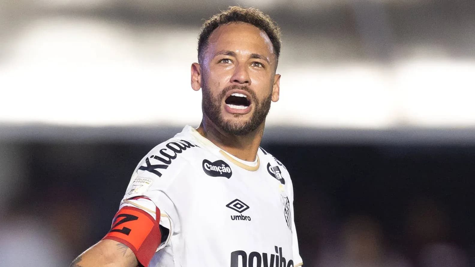 Jugador en uniforme de fútbol gritando en el campo