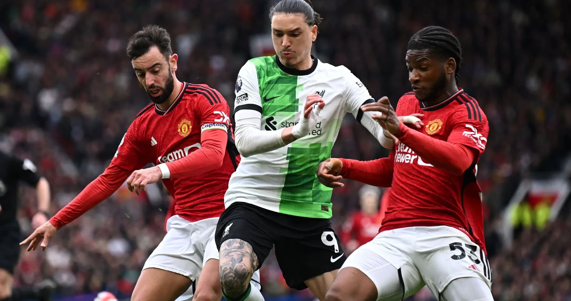 Jugadores de Liverpool y Manchester luchando por el balón