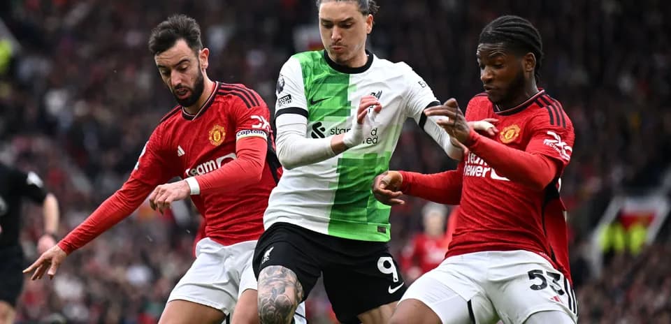 Jugadores de Liverpool y Manchester luchando por el balón