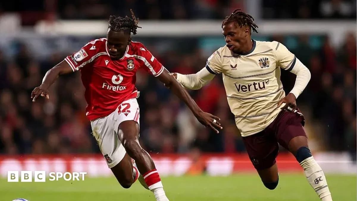 Jugador con camiseta roja driblando balón en el partido