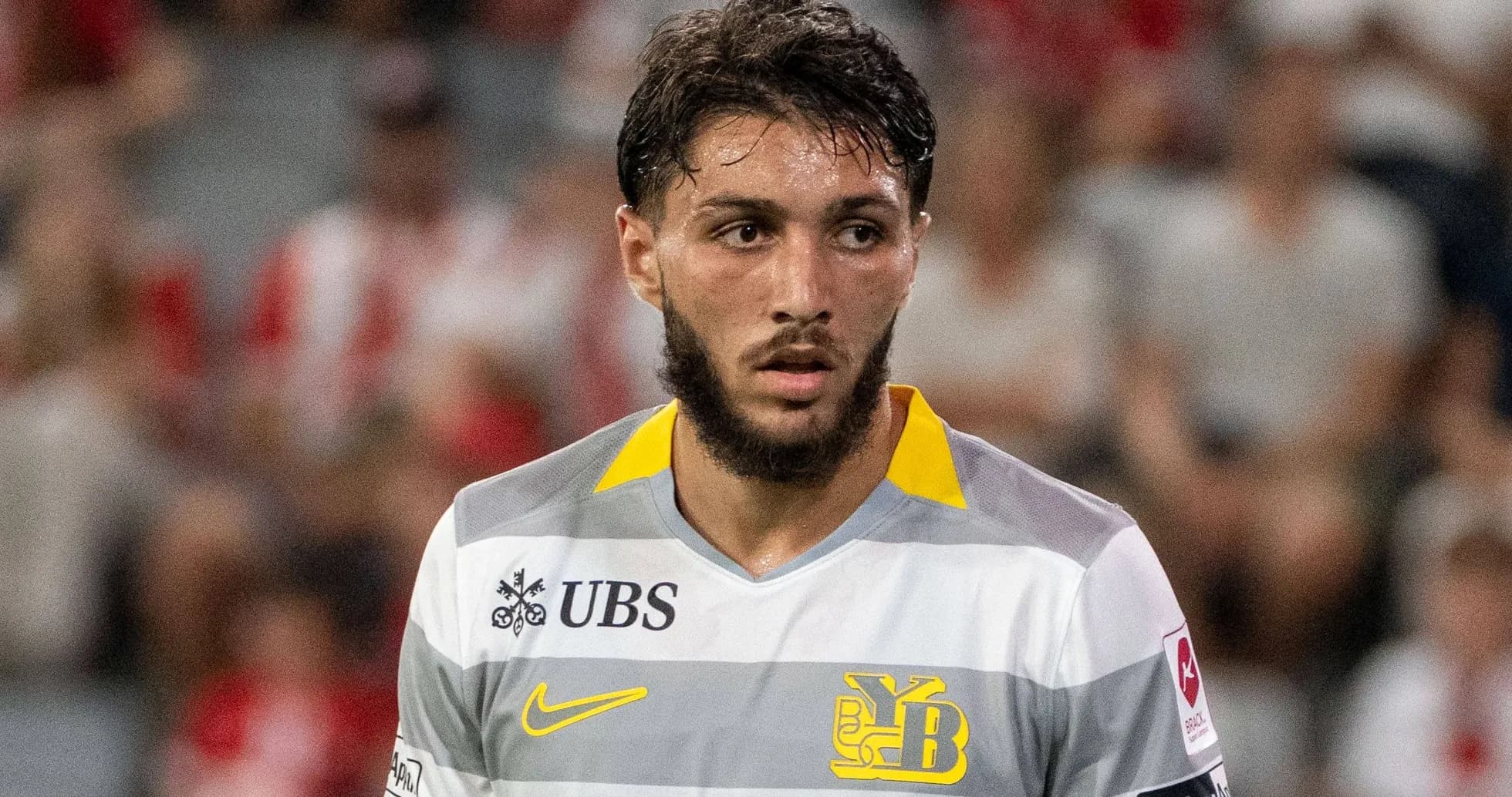 Jugador de fútbol con camiseta gris y amarilla