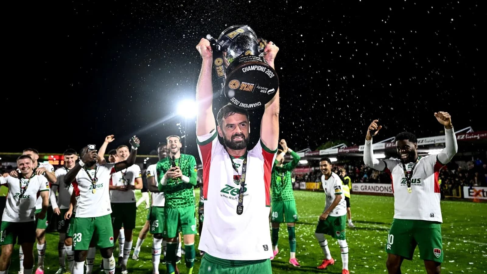 Jugador levantando trofeo con compañeros celebrando