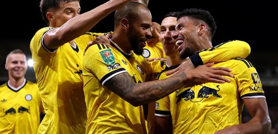 Jugadores celebrando un gol con camisetas amarillas